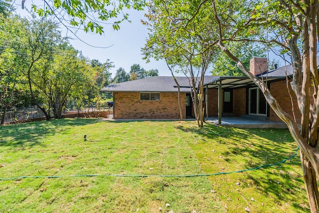 back of property with a yard and a patio area