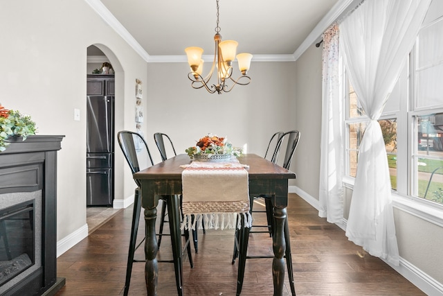 dining space with crown molding, a chandelier, and dark hardwood / wood-style flooring