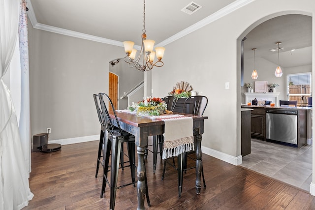 dining area with a notable chandelier, lofted ceiling, crown molding, and dark wood-type flooring