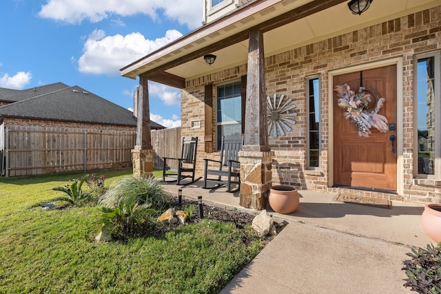 doorway to property featuring a yard and covered porch