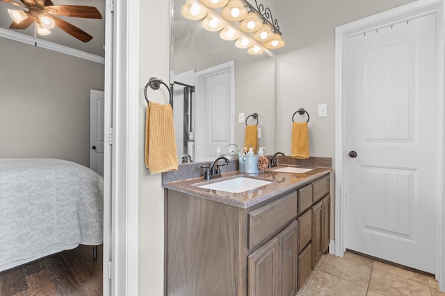 bathroom with ornamental molding, hardwood / wood-style flooring, vanity, and ceiling fan