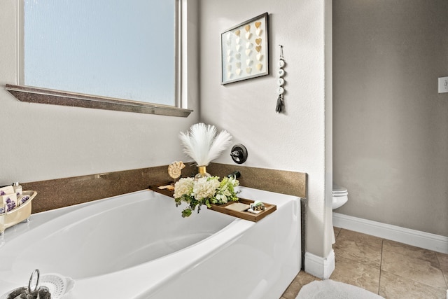 bathroom with tile patterned flooring, a bathtub, and toilet