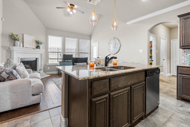 kitchen featuring light wood-type flooring, a center island with sink, sink, hanging light fixtures, and stainless steel dishwasher