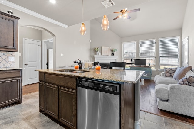 kitchen with stainless steel dishwasher, sink, vaulted ceiling, light hardwood / wood-style flooring, and a center island with sink