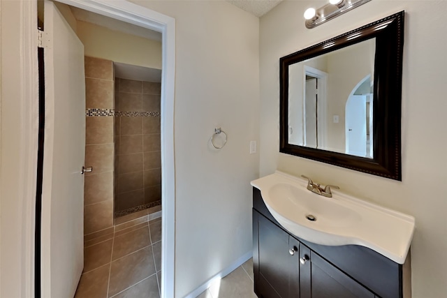 bathroom featuring tile patterned floors, vanity, and tiled shower