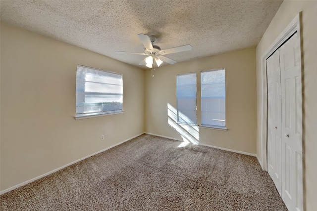 unfurnished bedroom with ceiling fan, a textured ceiling, a closet, and carpet