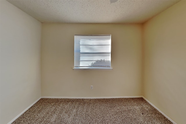 empty room with carpet floors and a textured ceiling