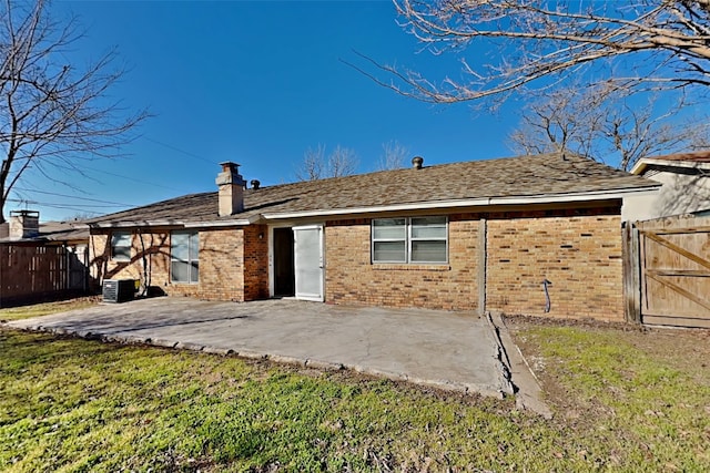 back of property with a patio, a yard, and central AC