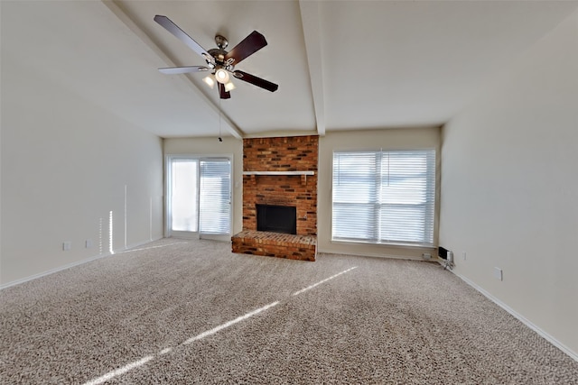 unfurnished living room featuring a brick fireplace, beamed ceiling, ceiling fan, and carpet flooring