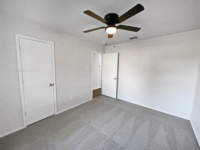 unfurnished bedroom featuring ceiling fan, carpet floors, and a textured ceiling