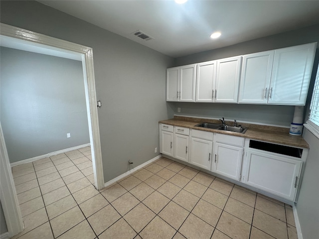 kitchen featuring light tile patterned flooring, white cabinetry, and sink