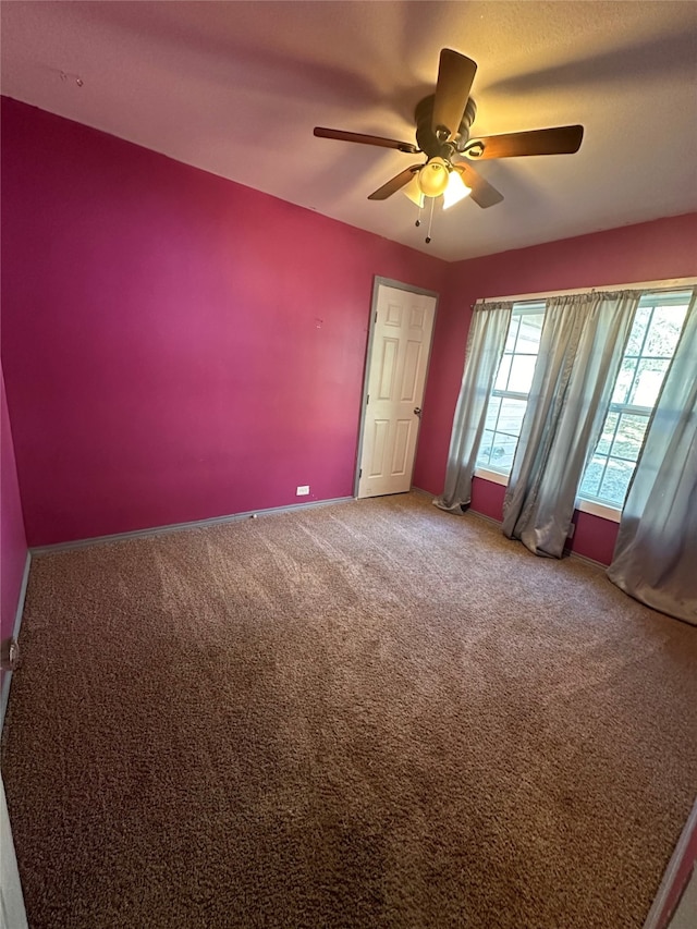 carpeted spare room featuring ceiling fan