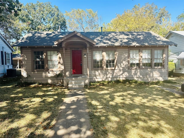 view of front of property featuring cooling unit and a front lawn