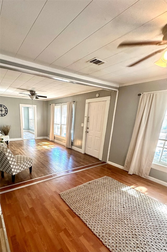 foyer entrance with crown molding, ceiling fan, wood-type flooring, and a wealth of natural light