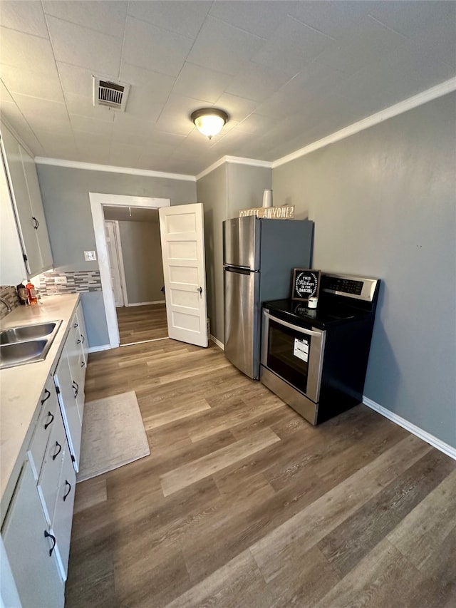 kitchen featuring appliances with stainless steel finishes, white cabinets, sink, and light wood-type flooring