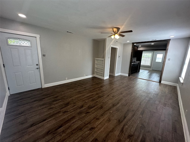 unfurnished living room with ceiling fan and dark wood-type flooring