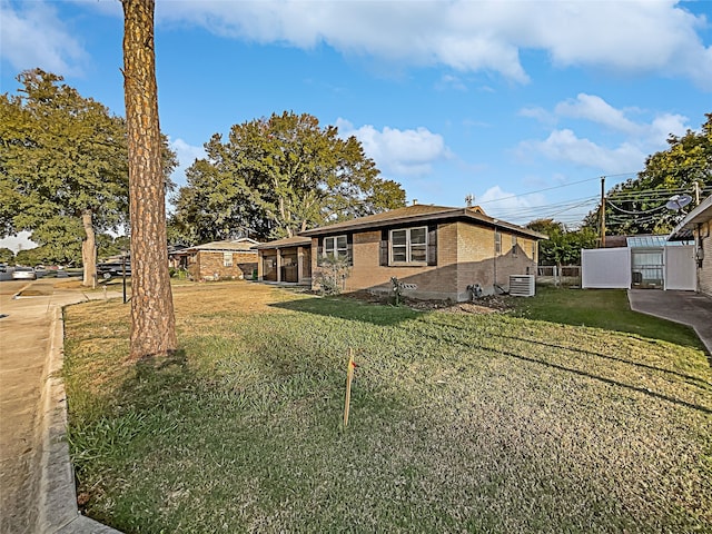 view of front facade featuring a front yard and central AC unit