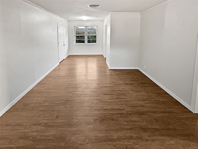 spare room with ornamental molding and dark hardwood / wood-style flooring