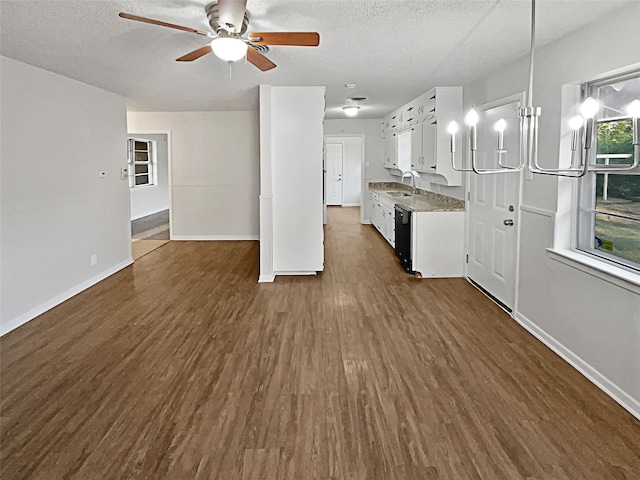 kitchen with dark wood-type flooring, light stone counters, white cabinetry, and a textured ceiling