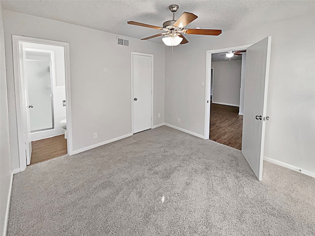 unfurnished bedroom featuring carpet flooring, ensuite bathroom, ceiling fan, a closet, and a textured ceiling