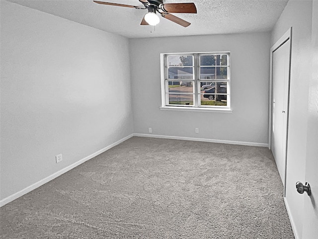 unfurnished room with ceiling fan, a textured ceiling, and carpet flooring