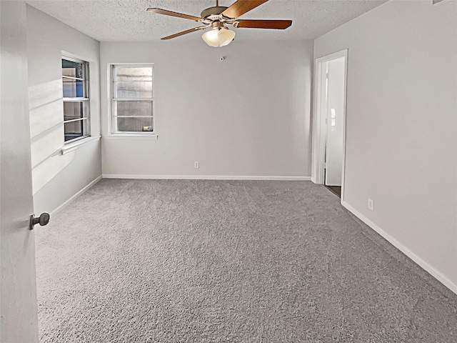 carpeted empty room featuring ceiling fan and a textured ceiling