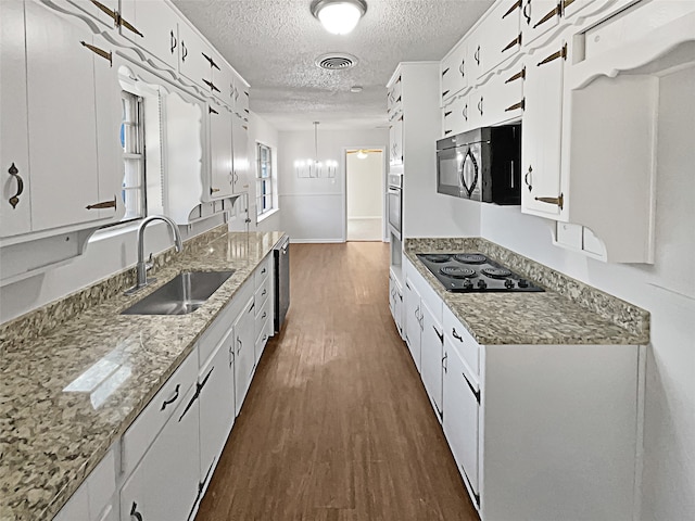 kitchen featuring pendant lighting, white cabinets, black appliances, and sink