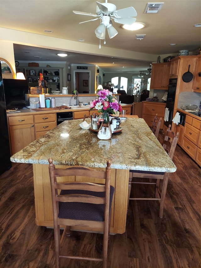 kitchen featuring kitchen peninsula, dark hardwood / wood-style floors, and black double oven