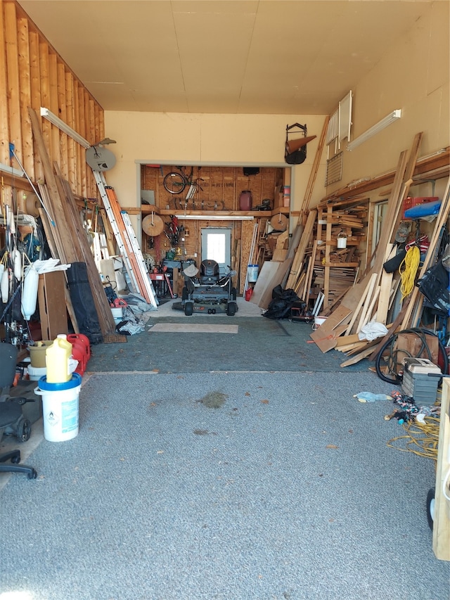 garage featuring a workshop area and wooden walls