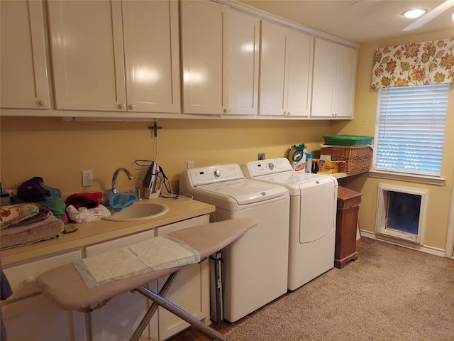 washroom featuring sink, washer and clothes dryer, and light carpet