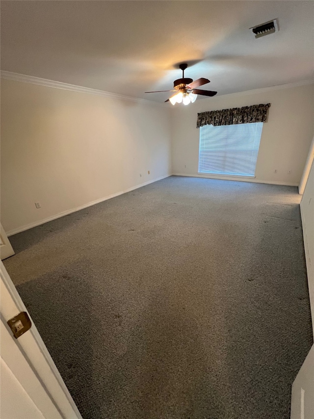 carpeted spare room featuring crown molding and ceiling fan