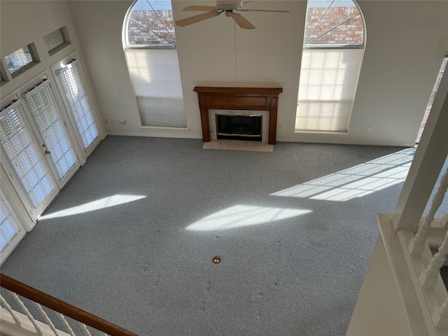 unfurnished living room featuring light colored carpet and a healthy amount of sunlight