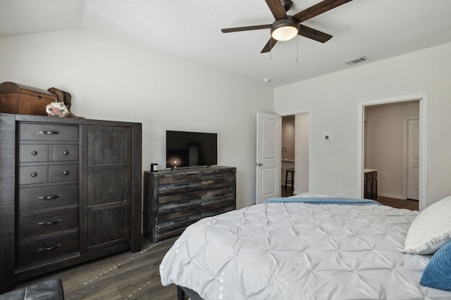 bedroom featuring ensuite bathroom, lofted ceiling, ceiling fan, and dark wood-type flooring