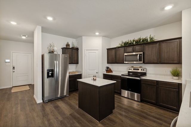 kitchen with dark hardwood / wood-style floors, appliances with stainless steel finishes, a kitchen island, and dark brown cabinets