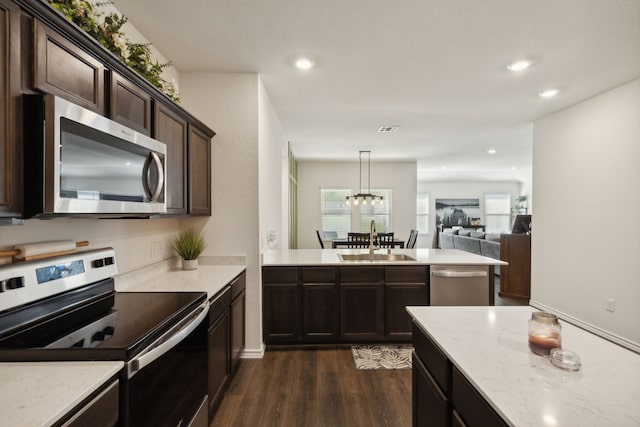 kitchen with dark brown cabinetry, dark hardwood / wood-style floors, sink, hanging light fixtures, and appliances with stainless steel finishes