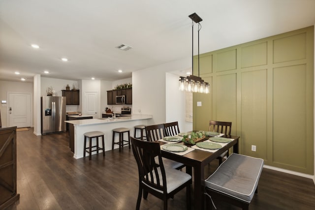 dining area featuring dark wood-type flooring and sink