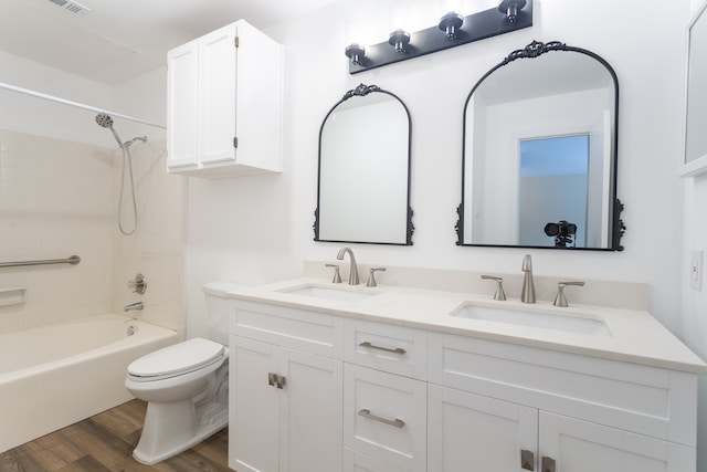 full bathroom with toilet, hardwood / wood-style flooring, vanity, and bathing tub / shower combination