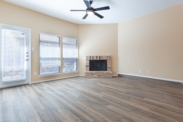 unfurnished living room featuring ceiling fan, wood-type flooring, and a fireplace