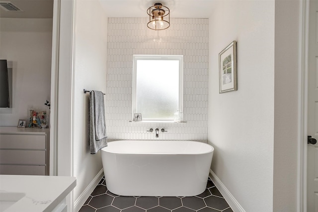 bathroom with a tub, tile patterned flooring, and vanity