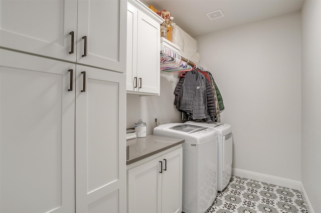 laundry area with separate washer and dryer and cabinets