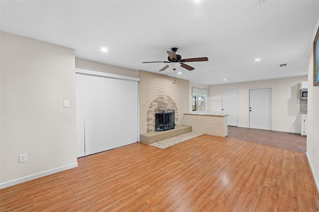 unfurnished living room with ceiling fan and light hardwood / wood-style flooring