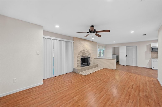 unfurnished living room with light wood-type flooring and ceiling fan