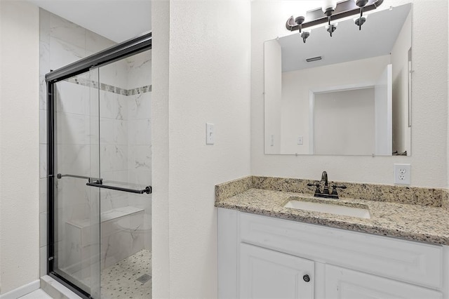 bathroom featuring vanity and a shower with door