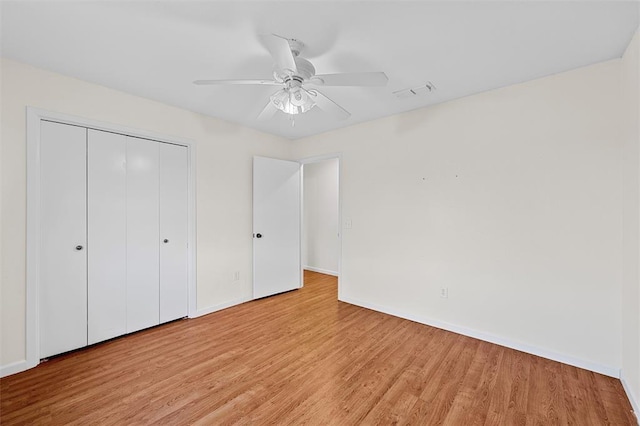 unfurnished bedroom featuring a closet, light hardwood / wood-style floors, and ceiling fan