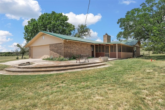 view of front of home featuring a sunroom, a garage, and a front lawn