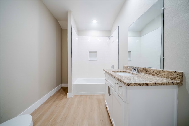 full bathroom featuring hardwood / wood-style floors, vanity, toilet, and tiled shower / bath combo