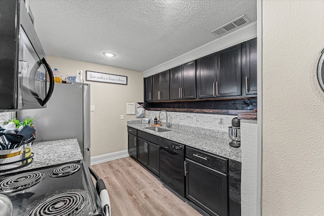 kitchen featuring range with electric stovetop, light stone counters, sink, and black dishwasher