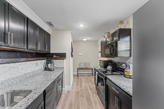 kitchen with black appliances, light stone countertops, backsplash, and a textured ceiling