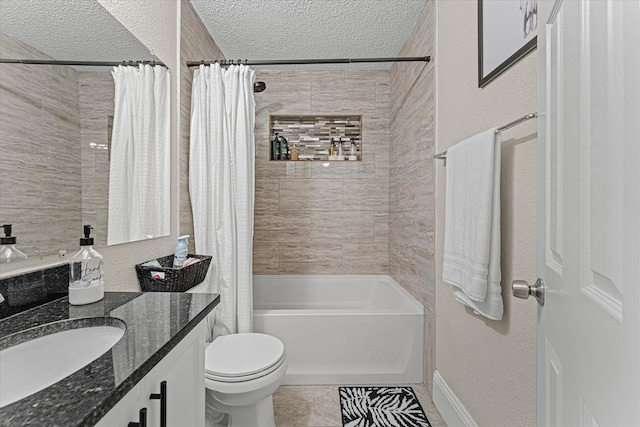 full bathroom featuring tile patterned floors, vanity, a textured ceiling, shower / bath combo with shower curtain, and toilet