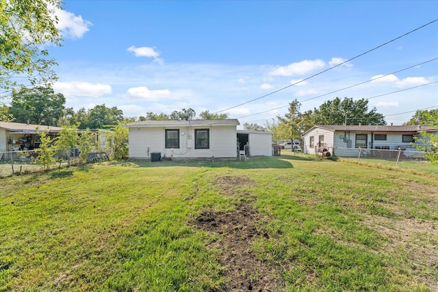 back of property with central AC and a yard